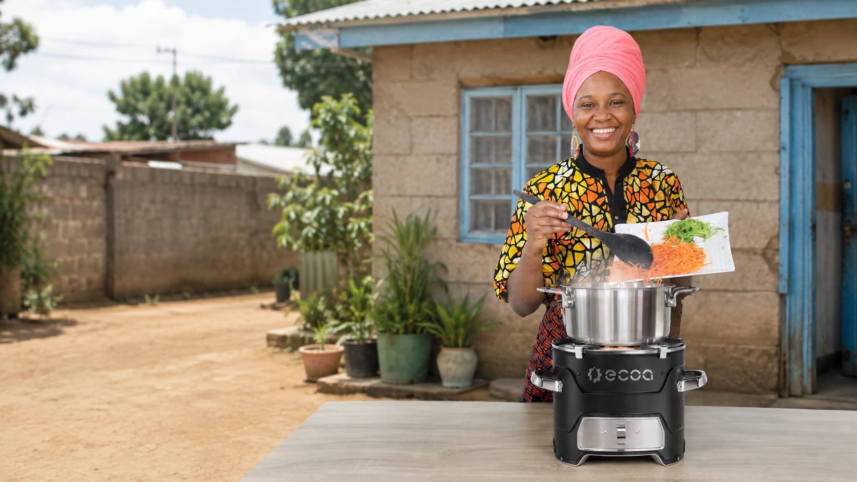 Woman showcasing the ECOA cookstove